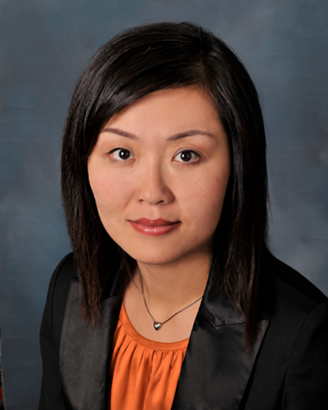 Jessie Zhou wearing a black jacket and orange blouse